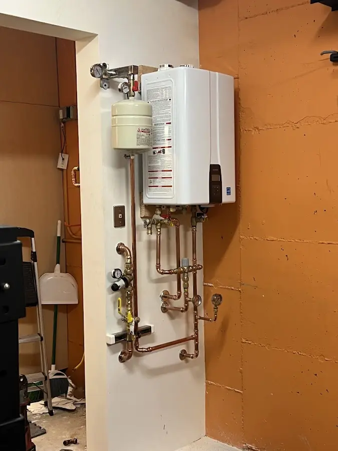 Plumbing technician inspecting water heater connections in Tuckahoe